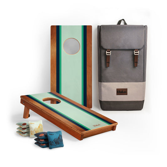 Cornhole boards with mint green striped design, cornhole bags, and a gray backpack 