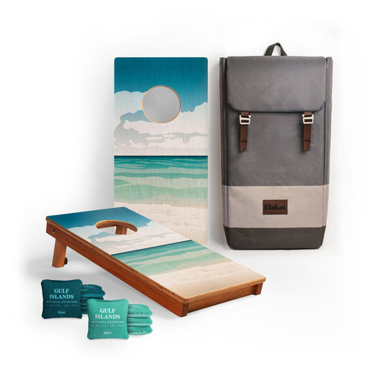 Cornhole board with beach-themed design, backpack, and Gulf Islands cornhole bags