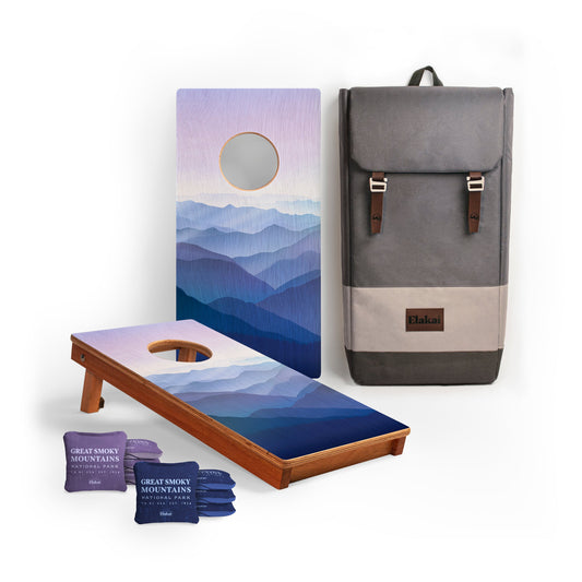 Cornhole board with mountain design, bean bags, and a gray backpack. Great Smoky Mountains
