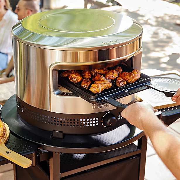 Portable pizza oven by solo stove with food being cooked outdoors